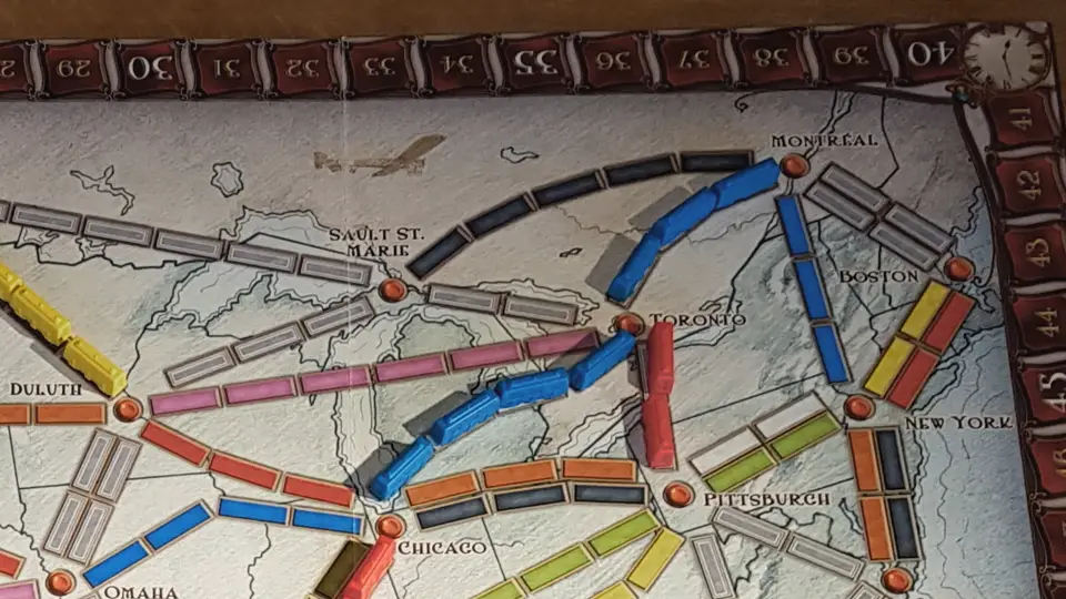 Blauer Zug fährt auf dem Spielbrett von Zug um Zug von alleine los und in den gelben Zug hinein